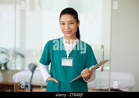 Porträt einer jungen lächelnden Krankenschwester des Rehabilitationszentrums mit Klemmbrett Stockfoto