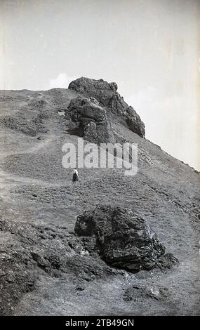 1950er Jahre, historisch, eine Dame auf einem Hügel zwischen einer Reihe von alten Felsen oder felsigen Vorposten in den Shropshire Hills, England, Großbritannien. An der Grenze zu Wales, in einem Gebiet, das als Welsh Marches bekannt ist, ist das Bergland der Hügel als AONB gelistet, ein Gebiet von herausragender natürlicher Schönheit. Die Landschaft der Shropshire Hills wird als „Britische Schweiz“ bezeichnet. Stockfoto