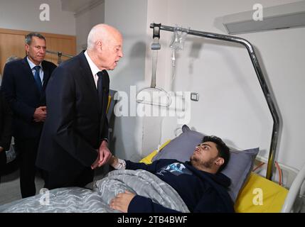 (231204) -- TUNIS, 4. Dezember 2023 (Xinhua) -- tunesischer Präsident Kais Saied (L, Front) besucht am 3. Dezember 2023 einen palästinensischen Patienten in einem Krankenhaus in Tunis, Tunesien. Saied sagte am Montag, dass alle verletzten Palästinenser, die in tunesische Krankenhäuser aufgenommen wurden, die notwendige Behandlung erhalten und gesund in ihre Heimat zurückkehren werden, so die tunesische Präsidentschaft. (Tunesischer Ratsvorsitz/Handout via Xinhua) Stockfoto