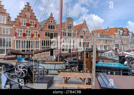 Traditionelle Boote, die im Innenhafen von Hoorn in den Niederlanden mit dem Kai von historischen Gebäuden vertäut sind Stockfoto