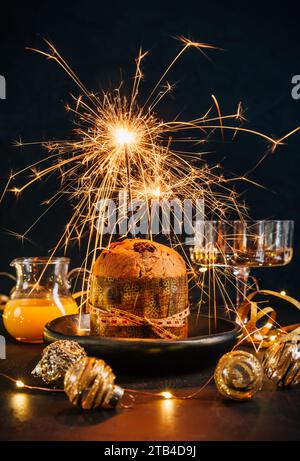 Traditioneller Weihnachtspanettone mit Schokolade, traditioneller italienischer Weihnachtskuchen mit Sparkler Stockfoto