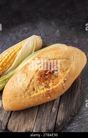 Frisches Maisbrot und Maiskörner auf dem Tisch. Nahrungsmittelkornkrisenkonzept. Nahaufnahme, Kopierbereich Stockfoto