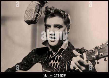 ELVIS PRESLEY ikonischer Popstar in den 1950er Jahren zu Beginn seiner Karriere, sang und spielte seine Gitarre in einem RCA Victor Aufnahmestudio mit Mikrofon der Ära. Hollywood USA 1955 Stockfoto