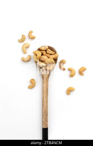Geröstete Cashewnüsse in Holzlöffel isoliert auf weißem Hintergrund, Blick von oben Stockfoto