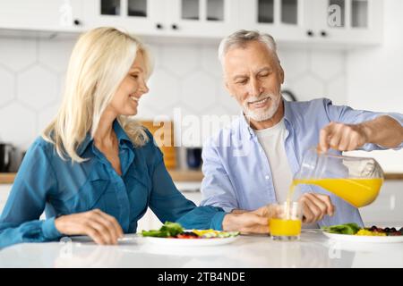 Fröhliche Ältere Ehepartner Genießen Gesundes Frühstück Zusammen In Der Küche Stockfoto