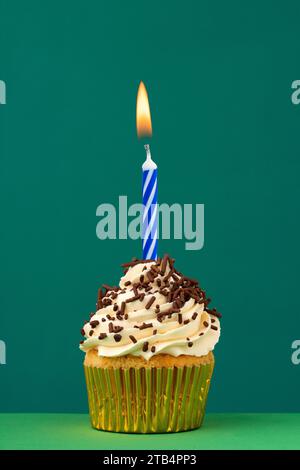 Geburtstagskerze mit Cupcake auf grünem Hintergrund Stockfoto