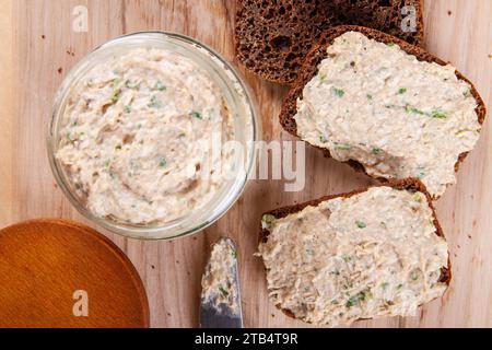 Rustikale Präsentation von Roggenbrot mit Aufstrich, wunderschön auf hölzernem Hintergrund angeordnet Stockfoto