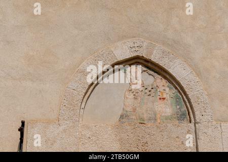 Das Portal im gotischen Stil wurde von Mauern ummauert und ist „Portal of Women“ mit Spuren eines Freskos auf dem ehemaligen Kloster Santa Caterina, Finalborgo, Finale Ligure Stockfoto