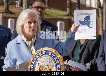 Senator Kirsten Gillibrand zeigt eine Landkarte des Staates mit Verteilung der Mittel für psychische Gesundheit, während er am 4. Dezember 2023 in New York einen Bericht über die Verhaftung illegaler Waffen und Beschlagnahme auf dem platz vor dem Polizeipräsidium veröffentlichte Stockfoto