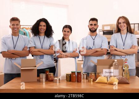 Porträt von Freiwilligen und Lebensmitteln am Tisch im Lager Stockfoto