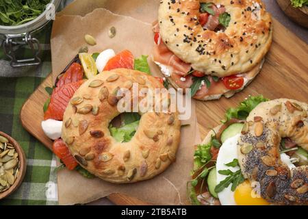 Leckere Bagel-Sandwiches auf Holzbrett, Blick von oben Stockfoto