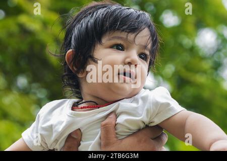 Porträt eines süßen indischen Jungen, der im Garten spielt. Stockfoto