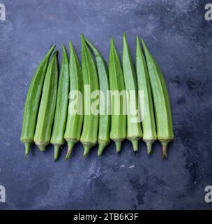 Frisches Bio-Gemüse Lady's Finger oder Okra auf dem dunklen Betonboden Stockfoto