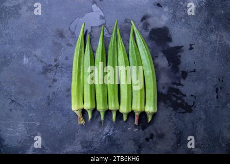 Frisches Bio-Gemüse Lady's Finger oder Okra auf dem dunklen Betonboden Stockfoto