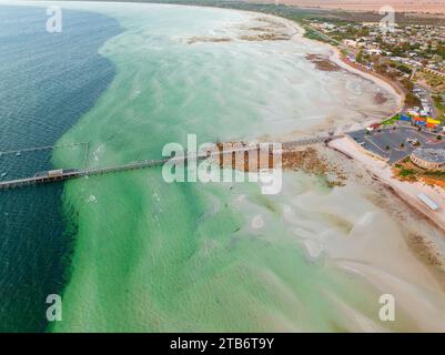 Aus der Vogelperspektive auf einen langen schmalen Steg, der über Felsen und einen breiten Strand bis zu tieferen Gewässern in der Moonta Bay auf der Yorke Peninsula in South Australia verläuft Stockfoto