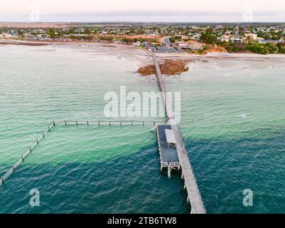 Aus der Vogelperspektive auf einen langen schmalen Steg, der über Felsen und Strand zum tieferen Wasser in der Moonta Bay auf der Yorke Peninsula in Südaustralien führt Stockfoto