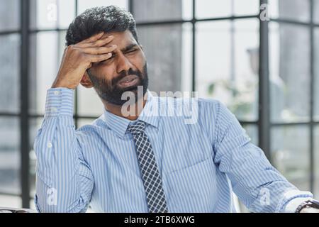 Ein nachdenklicher, zweifelhafter Geschäftsmann im Spannungsdenken macht die Entscheidung am Arbeitsplatz schwierig Stockfoto