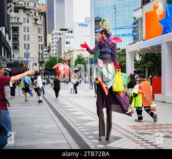 Stelzenläuferin begrüßt Fußgänger beim Weihnachtsfest in der Queen Street im Stadtzentrum von Auckland. Stockfoto