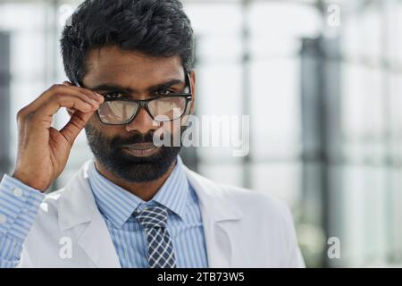 Porträt eines lächelnden männlichen Arztes, der in einem Krankenhausgang steht Stockfoto