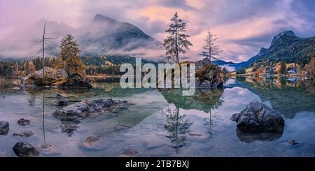 Ein 2:1-Panoramafoto eines Sonnenaufgangs im Herbst mit Morgennebel am Hintersee, einem See auf dem Gebiet der Gemeinde Ramsau bei Berchtesgade Stockfoto