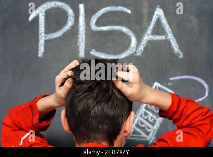 Schwerin, Deutschland. Dezember 2004. ILLUSTRATION - Schuljunge Arne reißt sich in Schwerin die Haare vor dem Wort „PISA“, das in Kreide auf eine Tafel geschrieben ist. Deutsche Schüler haben im internationalen PISA-Leistungsvergleich 2022 schlechter abgeschnitten als je zuvor. Sowohl im Lesen als auch in der Mathematik und Wissenschaft sind dies die niedrigsten Werte, die je in der Pisa-Studie für Deutschland gemessen wurden. Die Organisation für wirtschaftliche Zusammenarbeit und Entwicklung (OECD) kündigte am Dienstag in Berlin an, dass die durchschnittliche Leistung auch international drastisch zurückgegangen sei. Foto A/dpa/Alamy Live News Stockfoto