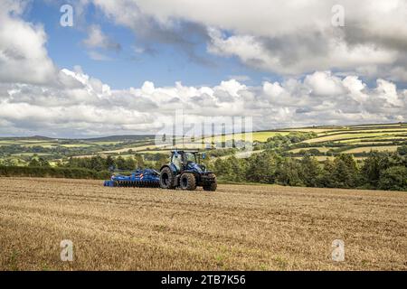 Grossbritannien: Cornwalls landwirtschaftliche Landschaft. New Holland T7 Flüssigerdgas-Traktor (LNG) mit unabhängiger Scheibenegge für die Stockfoto