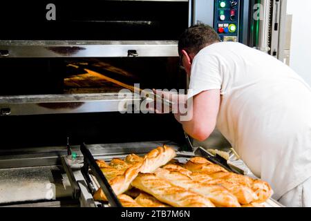 Bäckerei: Brotbackerei im Bäckerhaus. Abbildung einer Bäckerei, die mit einem Pelletbrotbackofen betrieben wird, Auswirkungen steigender Strompreise. Frisch Stockfoto