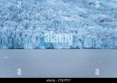 Im majestätischen Vatnajokull-Nationalpark von Island stehen markante blaue Eisformationen inmitten des kalten Wassers und zeigen die raue Schönheit der Natur. Stockfoto