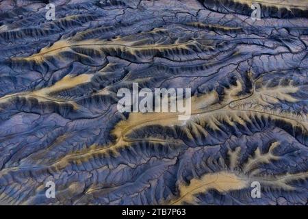 Aus der Vogelperspektive werden komplexe Muster von blauen Graten und Tälern in einem weiten Wüstengebiet gezeigt, die die Kunstfertigkeit der Natur hervorheben. Stockfoto