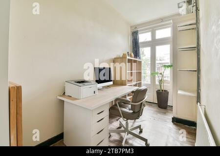 Moderner Arbeitsplatz mit Computer und Drucker auf dem Schreibtisch und Holzschrank im Heimbüro Stockfoto