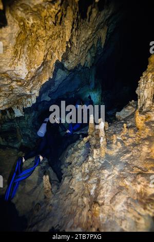 Hoher Winkel einer Gruppe anonymer Taucher, gegen die komplexen Strukturen der Cenote Dos Ojos in Mexiko, schwimmen durch enge Gänge umgeben Stockfoto