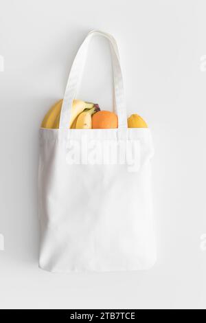 Weißer Beutel mit Obst auf einem weißen Tisch. Stockfoto