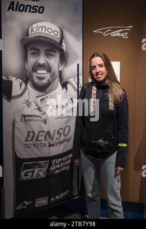 Ein junges Mädchen, das ein Fan von Fernando Alonso ist, macht ein Foto mit seinem Poster und seiner Unterschrift Stockfoto