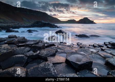 Sonnenuntergang über dem Weltkulturerbe Giant's Causeway an der Causeway Coast, Bushmills, County Antrim, Nordirland. Herbst (November) 2022. Stockfoto