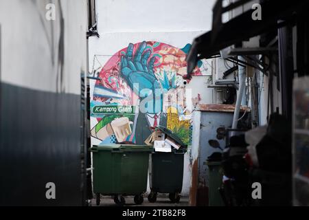 In der Hintergasse, die normalerweise schmutzig ist und grüne Mülltonnen zu sehen ist, aber mit einem Wandbild-Graffiti, um den langweiligen Raum in Singapur aufzumalen Stockfoto