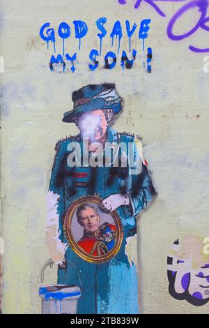 Lustige Graffiti von Königin Elizabeth, die ein Porträt ihres Sohnes Charles hält. Stockfoto