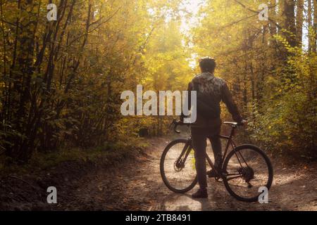 Radfahrer fahren auf einer Strecke in einem wunderschönen Herbstwald. Sport- und Erholungskonzept. Stockfoto