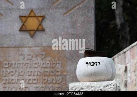 Ein Steinmarker auf dem Gelände des Mt. Herzl Militärfriedhof in Jerusalem. Eingeprägt mit dem hebräischen Wort für „erinnern Sie sich“ und einer Mauer, auf der steht „zu r Stockfoto