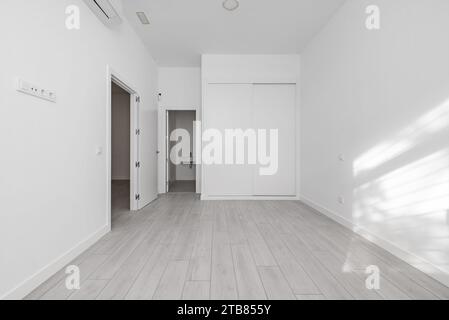 Schlafzimmer eines Loft-Hauses mit einem weißen Einbauschrank Stockfoto