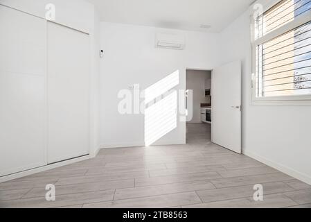 Schlafzimmer in einem Haus im Loft-Stil mit einem weißen Einbauschrank Stockfoto