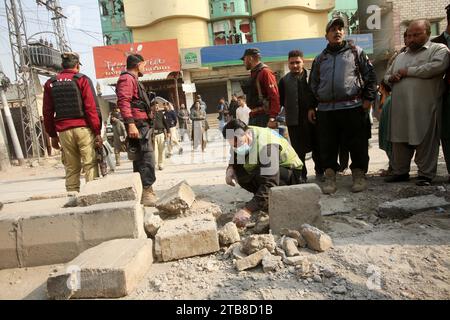 Peschawar, Pakistan. Dezember 2023. Sicherheitspersonal untersucht die Sprengstelle in Peshawar, Pakistan, 5. Dezember 2023. Sieben Menschen, darunter vier Kinder, wurden am Dienstag bei einer Explosion vor einer Schule in Pakistans nordwestlicher Provinz Khyber Pakhtunkhwa verletzt. Quelle: Umar Qayyum/Xinhua/Alamy Live News Stockfoto