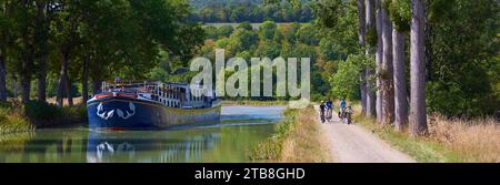 Gissey-sur-Ouche (Nordostfrankreich): Hotel-Barge L’Impressioniste und Touristen auf dem Fahrrad an der Schleuse 34S am Canal de Bourgogne Stockfoto