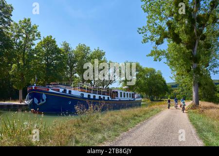 Gissey-sur-Ouche (Nordostfrankreich): Hotel-Barge L’Impressioniste und Touristen auf dem Fahrrad an der Schleuse 34S am Canal de Bourgogne Stockfoto