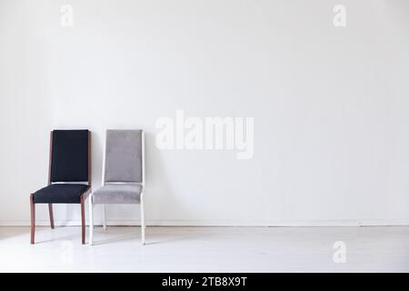 Zwei farbenfrohe Stühle im Inneren eines weißen leeren Zimmers Stockfoto