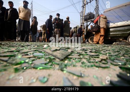 Peshawar, Peshawar, Pakistan. Dezember 2023. Zersplittertes Glas bedeckt den Boden, während pakistanische Sicherheitsbeamte am 5. Dezember 2023 den Ort der Explosion eines improvisierten Sprengstoffs (IED) an einem Straßenrand in Peshawar, Pakistan, untersuchen. Mindestens sieben Menschen, darunter drei Kinder, wurden bei einer Explosion auf Polizeipersonal verletzt und ereigneten sich auf der Warsak-Straße in Peshawar, sagten Polizei- und Krankenhausbeamte. Kashif Aftab Abbasi sagte, dass das Fahrzeug der Machnigate Polizeiwache auf Routinepatrouille war, als die Bombe explodierte. Quelle: ZUMA Press, Inc./Alamy Live News Stockfoto