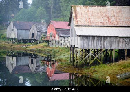 Alte hölzerne Bootshäuser auf Stelzen, die sich im Wasser spiegeln; Petersburg, Alaska, Vereinigte Staaten von Amerika Stockfoto