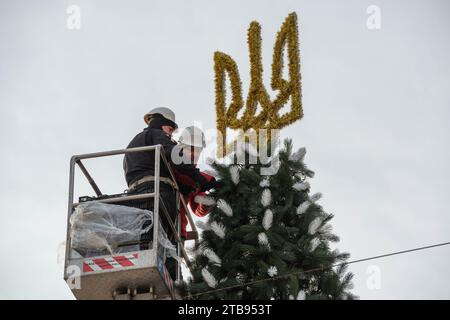 5. 12. 2023 Kiew, Ukraine. Stadtarbeiter schmücken den Weihnachtsbaum mit Dreizack Stockfoto