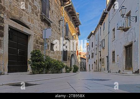 Bild einer typischen Straßenszene aus der historischen kroatischen Stadt Voznjan mit Kopfsteinpflasterstraßen und alten Gebäuden im Morgenlicht Stockfoto