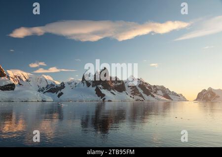 Reflexionen von Klippen und Bergen im Lemaire-Kanal bei Sonnenuntergang; Antarktis Stockfoto