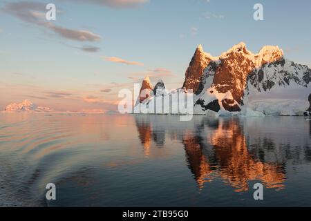 Reflexionen von Klippen und Bergen im Lemaire-Kanal bei Sonnenuntergang; Antarktis Stockfoto